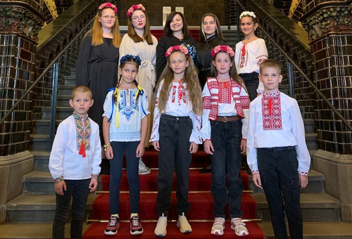 Kinder in traditioneller ukrainischer Kleidung stehen auf Treppe